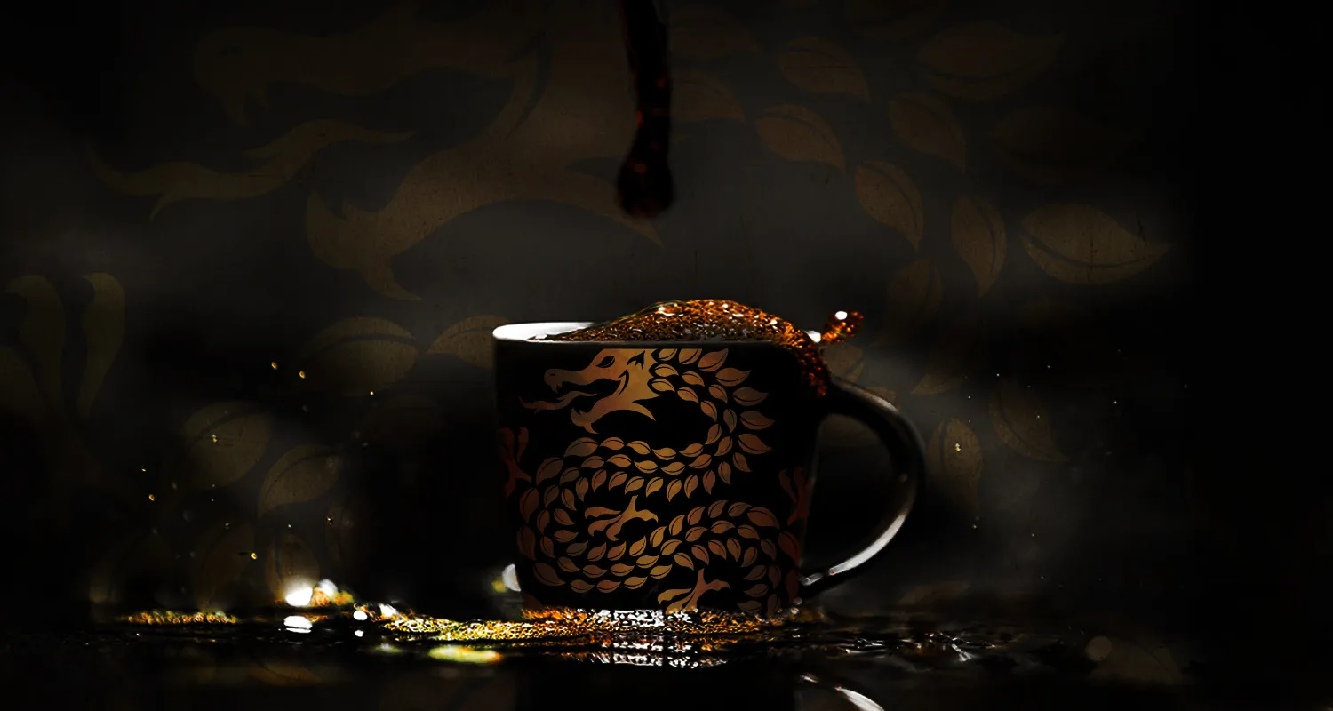 A Dragon Gongfu cup lit against a dark ground, the gold dragon wrapping the vessel