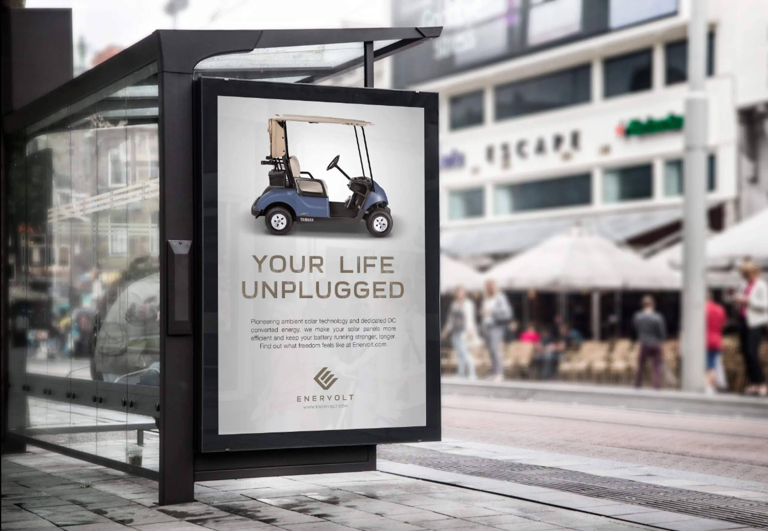 An Enervolt out-of-home poster in a street bus shelter, headed Your Life Unplugged, showing a solar-topped golf cart above the brand mark