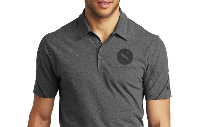 A grey polo shirt worn with the mark and the name printed on the chest