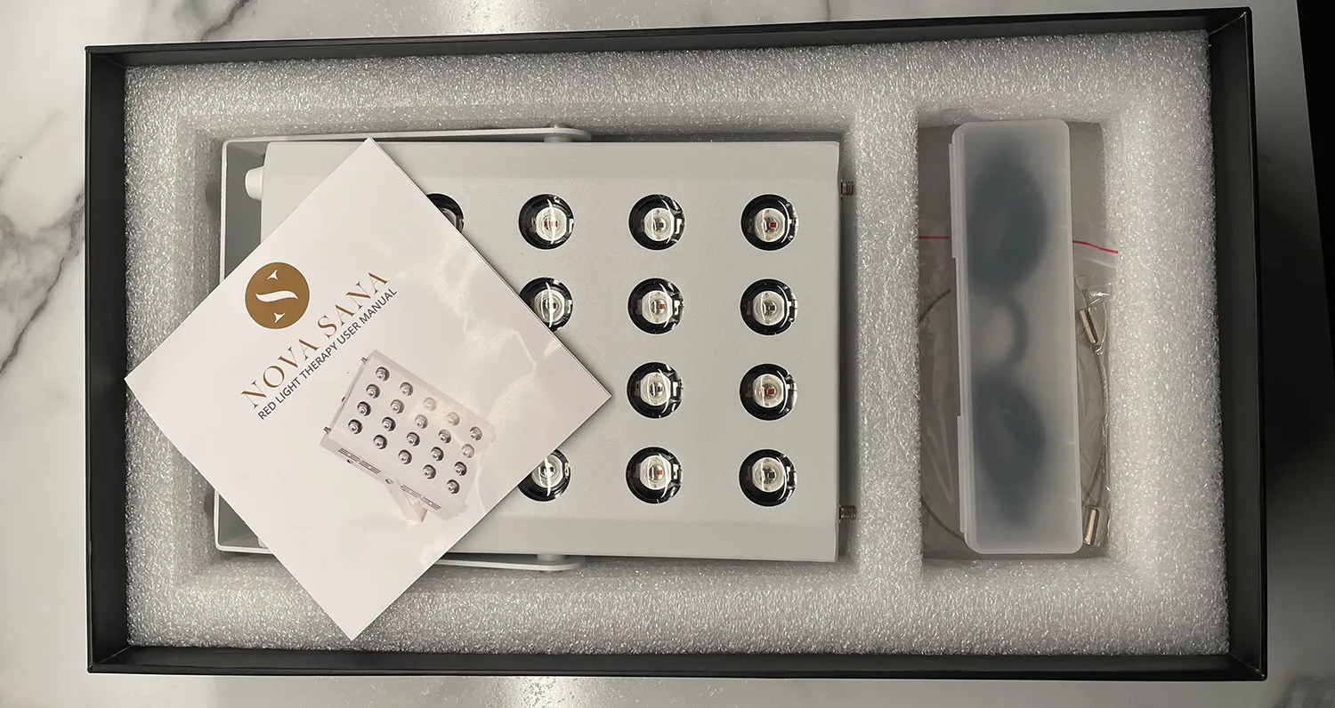 The opened box: the panel seated in its foam tray beside the goggles, with the printed manual laid on top